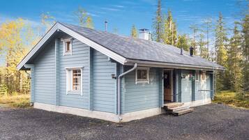 A single-story house with a gabled roof, a front porch, and a gravel driveway.