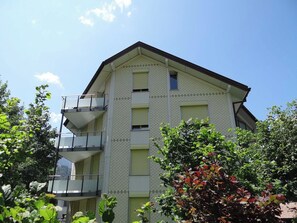 A multi-story building with balconies and a flat roof.