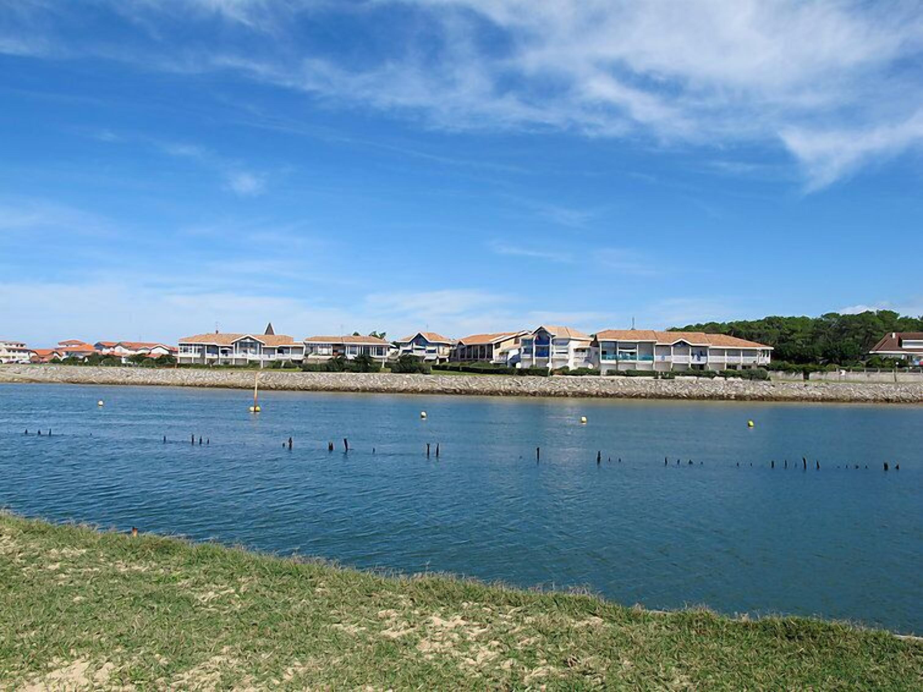 A waterfront hotel with multiple buildings, a calm lake, and a clear sky.