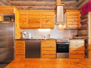 Una cocina con armarios de madera, electrodomésticos de acero inoxidable y salpicadero de azulejos.