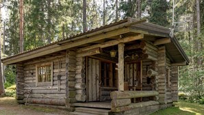 A rustic log cabin with a porch, wooden steps, and a chimney. - Rinnekämppä by Interhome (Asikkala)