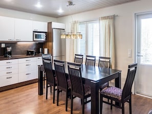 A modern kitchen with white cabinets, a microwave, and a coffee maker.