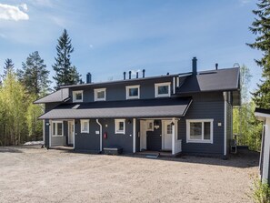 Un bâtiment à deux étages doté d’un porche à l’avant, de nombreuses fenêtres et d’une allée gravillonnée.