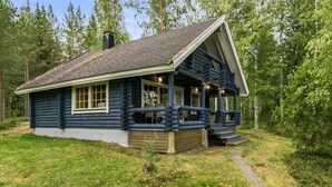 A log cabin with a porch, a chimney, and a pathway leading to the entrance. - Vacation home Tiira by Interhome (Puumala)