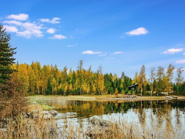 A cabin by a lake with a forest backdrop. - Vacation home Tiira by Interhome (Puumala)