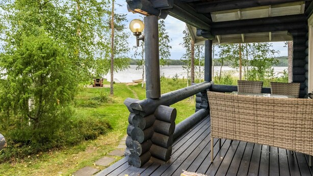 A wooden deck with a wicker table and chairs, overlooking a lake. - Vacation home Tiira by Interhome (Puumala)