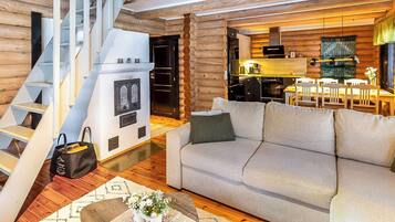 Een modern interieur met een trap, een bank, een eethoek en een keuken.