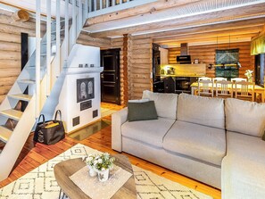 Een modern interieur met een trap, een bank, een eethoek en een keuken.