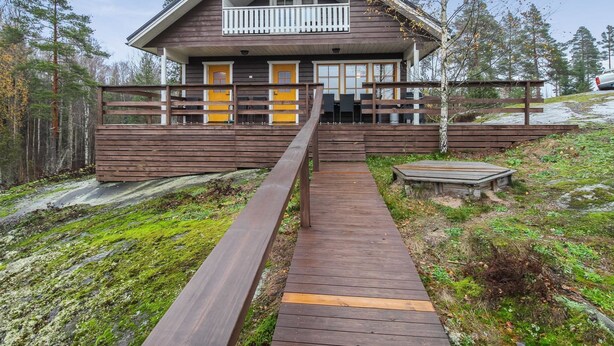 A wooden cabin with a balcony, a wooden deck, and a forested backdrop. - Dominus by Interhome (Raasepori)