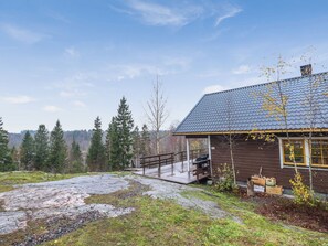 A cabin with a wooden exterior, a stone pathway leading to it, and a forested backdrop. - Dominus by Interhome (Raasepori)
