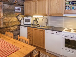 Une cuisine avec des meubles en bois, un four à micro-ondes, une machine à café, un évier et une cuisinière.