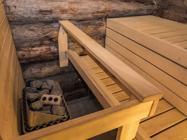 Un banc et une table en bois, placés contre un mur rustique fait de rondins.