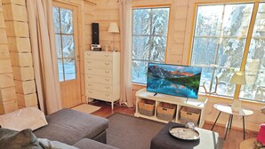 A cozy living room with a sofa, a TV, and a dresser. - Ihtingin koskikara by Interhome (Kuusamo)