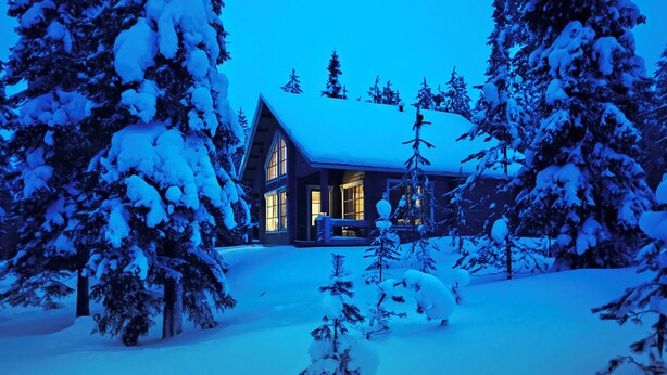 A cabin with a large front porch, surrounded by snow-covered trees. - Ihtingin koskikara by Interhome (Kuusamo)