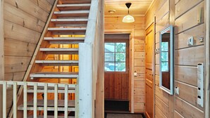 A wooden interior with a staircase, a window, and a door. - Ihtingin koskikara by Interhome (Kuusamo)