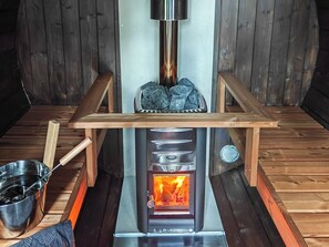 Een houtkachel met een metalen bovenkant en een vuur erin.