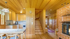 A wooden interior with a kitchen, dining area, and fireplace.
