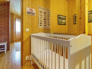 Un intérieur en bois avec un berceau, un panneau « interdiction de fumer » et une affiche présentant différentes espèces de poissons.