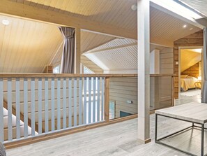 A spacious attic room with a high ceiling, wooden beams, and a view of the lower level. - Sopukka by Interhome (Sotkamo)