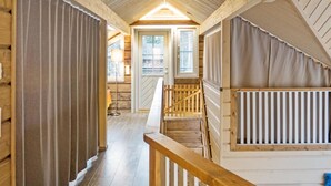 Interior de fusta amb una escala que mena a un dormitori a l'altell.