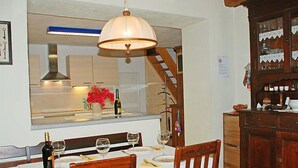 A dining area with a table set for two, a wine bottle, and glasses. A large mirror reflects the kitchen area above. - Strecce 2 by Interhome (Vergeletto)