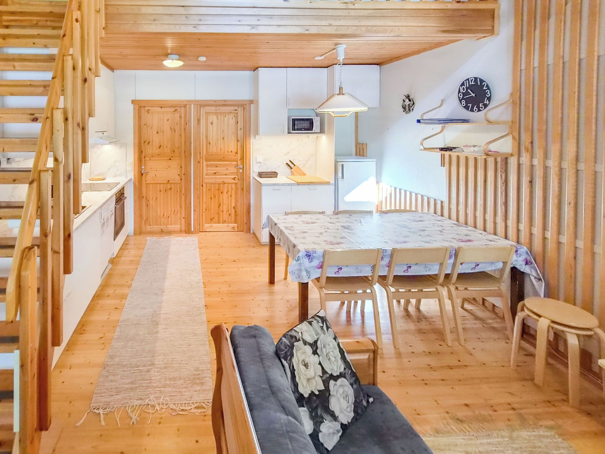 Un intérieur en bois comprenant un coin repas, un canapé et un escalier.