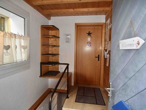 A wooden staircase with a metal handrail leading to a door with a star decoration. - Bühl 13 Appartement/Fewo 8-Bettwohnung by Interhome (Engelberg)