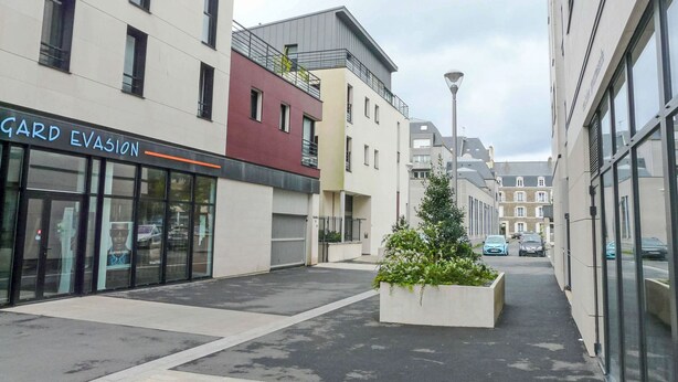 A modern urban street with a storefront named 'GARD EVASION'.