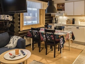 Cozy living space with a dining area, TV, and fully equipped kitchen.