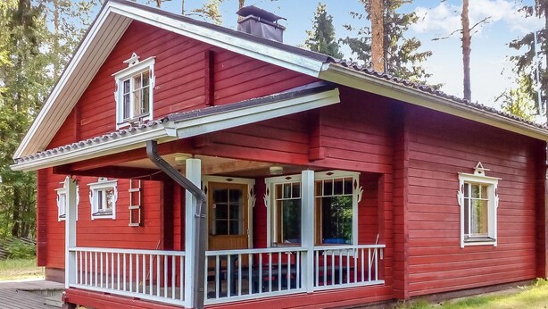 A red wooden house with a porch, white railings, and a small deck. - Vaahtera by Interhome (Kaavi)