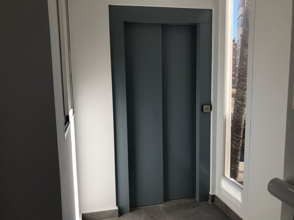 A closed door with a window to the right.