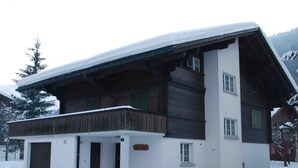 A two-story chalet with a wooden balcony and a snow-covered roof. - Elena # 1 by Interhome (Lenk)
