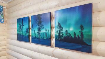 Three paintings of a forest at night with a starry sky on a wooden wall.