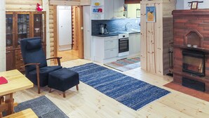 A cozy log cabin interior with a dining area, a kitchen, and a fireplace. - Lassinmaja by Interhome (Hartola)