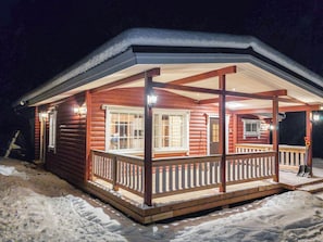 A log cabin with a covered porch and a snow-covered roof. - Lassinmaja by Interhome (Hartola)