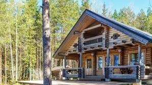 A log cabin with a porch, wooden steps, and a view of the surrounding forest. - Honkala by Interhome (Soini)