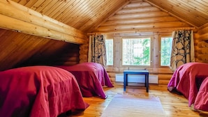 A cabin with two beds, a small table, and a window with curtains. - Honkala by Interhome (Soini)
