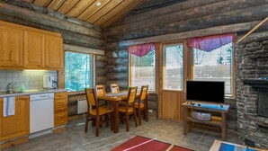 A log cabin interior with a kitchen, dining area, and a fireplace. - Rinnekieppi 1 by Interhome (Kuusamo)