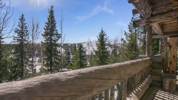 A wooden balcony with a view of snow-covered mountains and trees. - Rinnekieppi 1 by Interhome (Kuusamo)