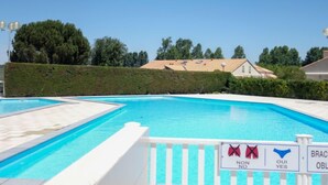 A swimming pool with a white fence and a sign indicating no diving.