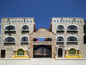 A hotel with a central entrance, multiple balconies, and a sign reading "Hotel Colonial".