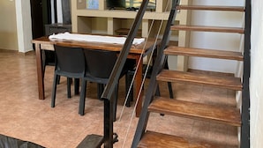A staircase with wooden steps and black railings leading to an upper floor. - La Divina Pereza (San Rafael)