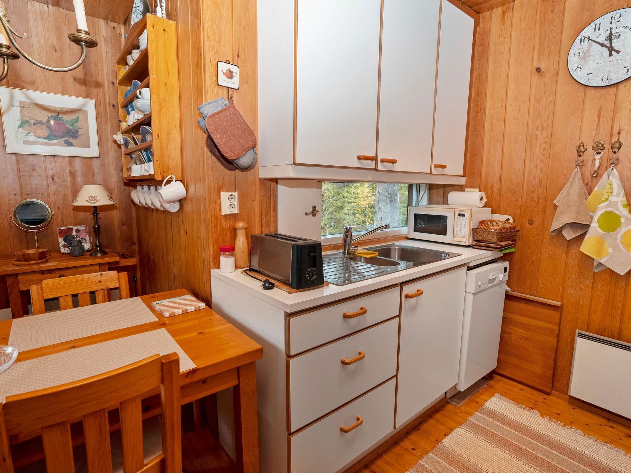 Een koelkast, een magnetron, een vaatwasser, kookgerei, borden en bestek