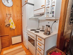 A compact kitchen with a stove, oven, and a coffee maker on the counter.
