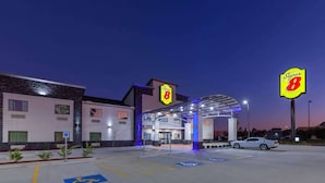 Ein Super 8 Hotel mit zweistöckiger Bauweise, einer überdachten Einfahrt und einem Parkplatz mit barrierefreiem Zugang.