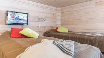 Une cabine comprenant deux lits, un téléviseur fixé au mur et un plafond en bois.