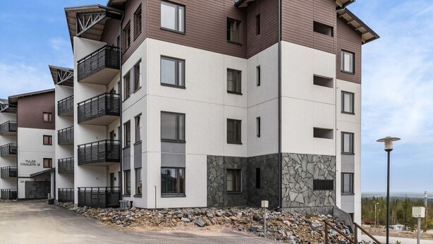 A multi-story residential building with balconies, a stone facade, and a clear sky. - Nordic chalet 9408 by Interhome (Ylläsjärvi)
