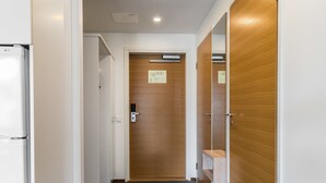 A hallway with a wooden door, a white wall, and a grey carpet. - Nordic chalet 9408 by Interhome (Ylläsjärvi)