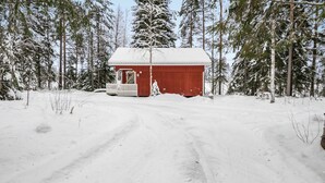 A small red cabin with a porch, surrounded by snow-covered trees and a clear sky. - Vacation home Rajala by Interhome (Kaavi)