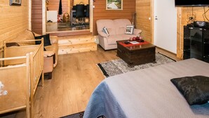 A cozy wooden cabin with a bed, a sofa, a small table, and a television. - Mäntymäki by Interhome (Raasepori)